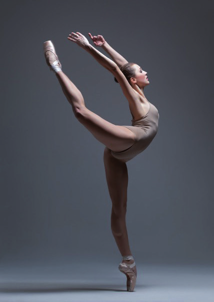 Danseuse classique en pointe réalisant une cambré arrière avec les bras en l'air